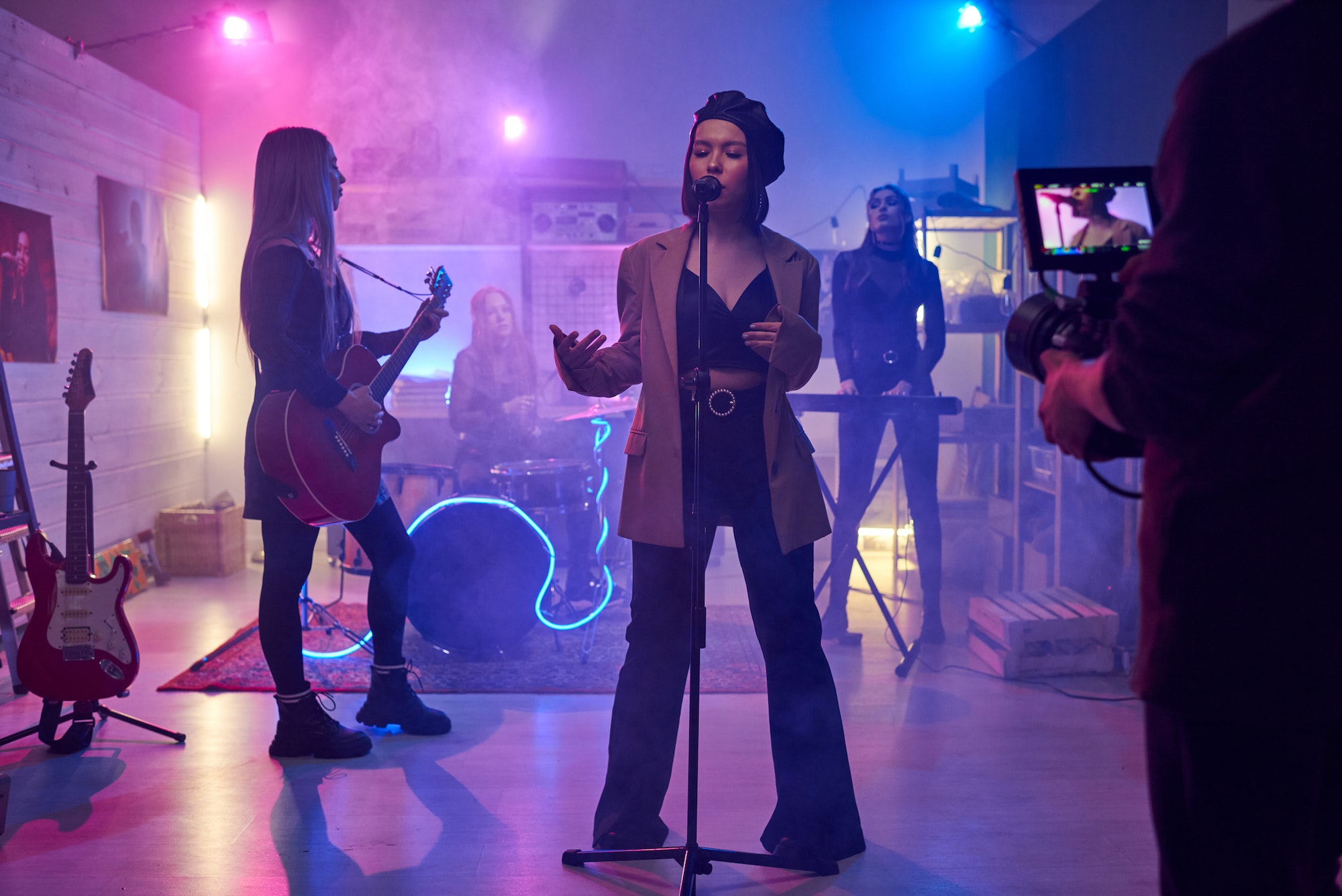Young female singer standing on stage in front of cameraman